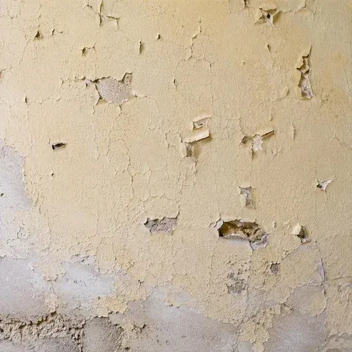 Cracked plaster wall with a flaking surface in a century St. Catharines home