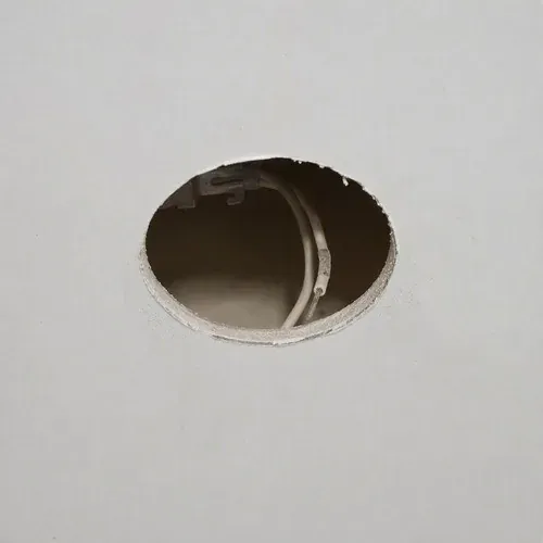 Round pot light hole left open in a ceiling after a recessed fixture was removed